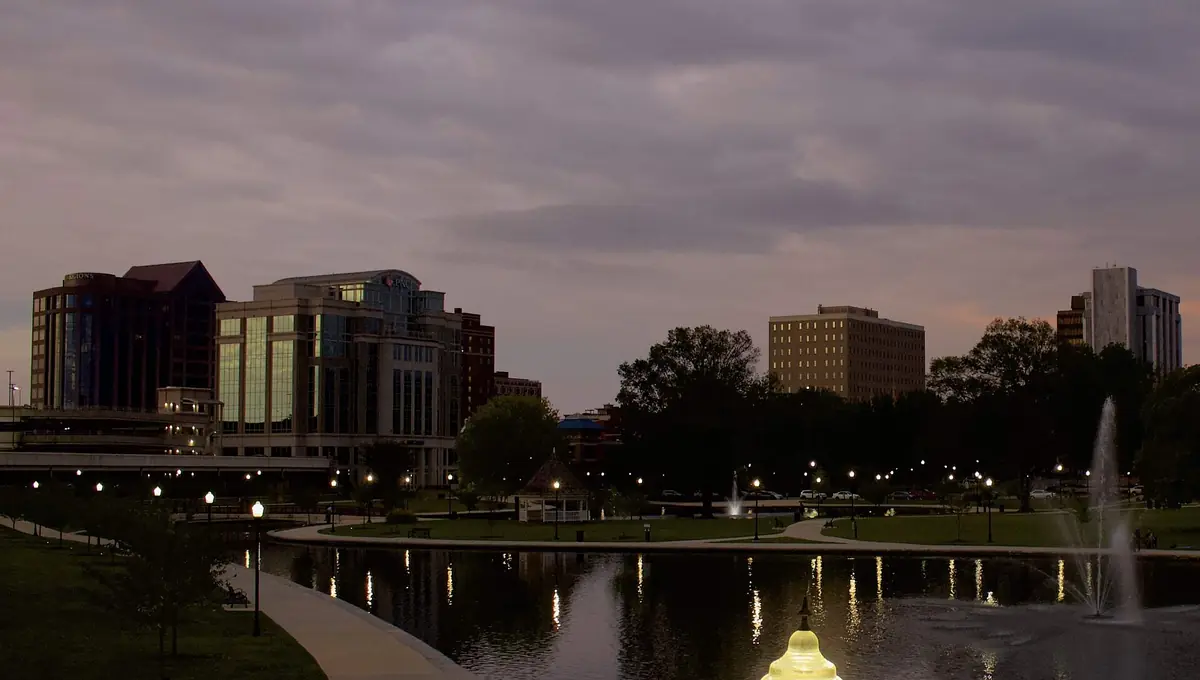 Downtown Huntsville office towers at dusk, reflected in the pond at Big Spring Park